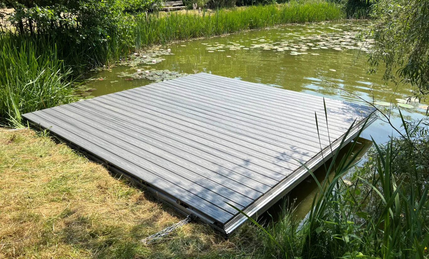 Schwimmsteg auf Aluminium Profilen, bestückt mit Holzdielen in einem Gartenteich